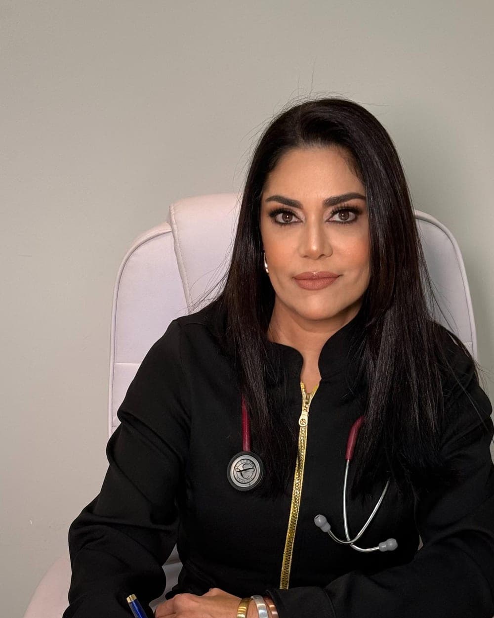 A Dra. Luciana Lemes à mesa do consultório, escrevendo